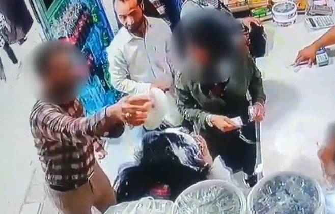 지난달 30일(현지시간) 이란 북동부 도시 마슈하드 근처의 한 마을에서 한 남성이 히잡을 착용하지 않은 모녀의 머리에 요구르트를 붓고 있다.(BBC 갈무리) /사진=뉴스1