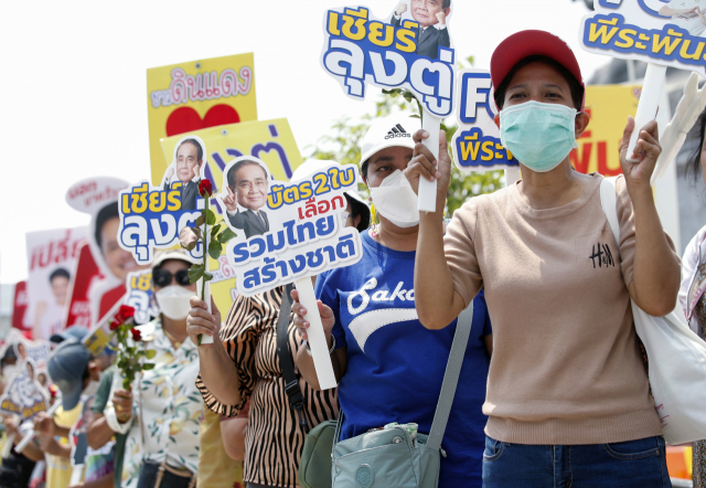 4일(현지 시간) 태국 방콕에서 총선을 앞두고 입후보 등록이 진행된 가운데 쁘라윳 짠오차 총리의 지지자들이 플래카드를 들고 있다.EPA연합뉴스