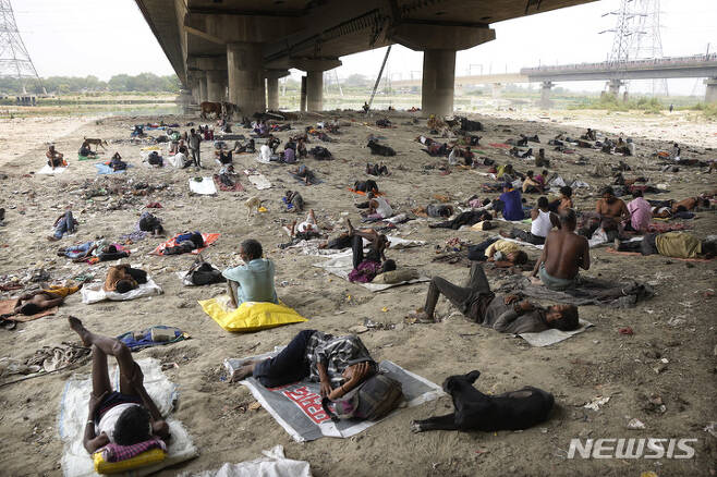 [뉴델리=AP/뉴시스]2022년 5월20일 인도 뉴델리의 다리 밑 그늘에서 노숙인들이 잠을 자고 있다. 인도 마하라슈트라주 나비 뭄바이에서 16일 이글거리는 뙤약별 아래 몇시간 동안 이어진 시상식에 참석한 사람 11명이 열사병으로 숨지고, 많은 사람들이 병원에 입원했다고 BBC가 17일 보도했다. 시상식은 인도 정부가 후원했다. 2023.04.17.
