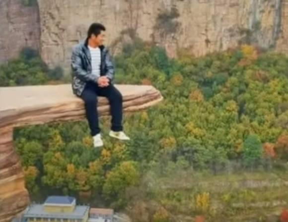 한 중국인 등산객이 절벽 바위에 올라 사진을 찍고 있다. SNS 캡처