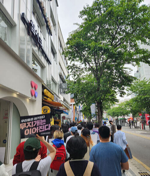 ‘무지개는 이어진다’라고 적힌 피켓을 든 집회 참석자가 서울 서대문구 연세로를 따라 행진하고 있다.