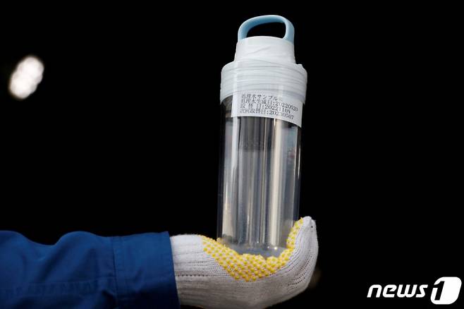 (오쿠마 로이터=뉴스1) 권진영 기자 = 8일 일본 후쿠시마현 제1 원자력발전소에서 도쿄전력 직원이 ALPS로 정화 작업을 마친 방사능 오염수가 담긴 병을 들고 있다. ⓒ 로이터=뉴스1 Copyright (C) 뉴스1. All rights reserved. 무단 전재 및 재배포 금지.