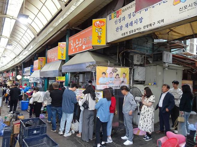 신포국제시장 내 닭강정 가게 앞에 닭강정을 사려는 손님들이 줄을 서서 기다리고 있다.