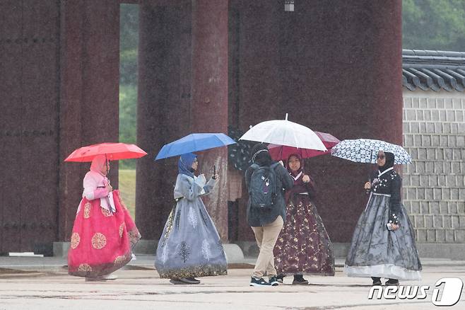지난 28일 외국인 관광객들이 우산을 쓰고 서울 경복궁을 돌아보고 있다./사진=뉴스1.