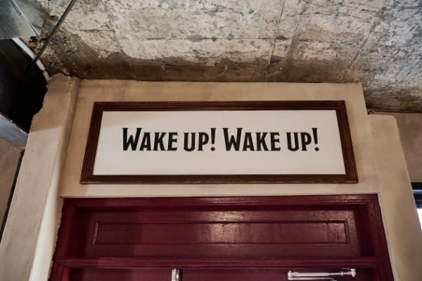 출입구 위에 쓰여진 문구 'WAKE UP!'.
