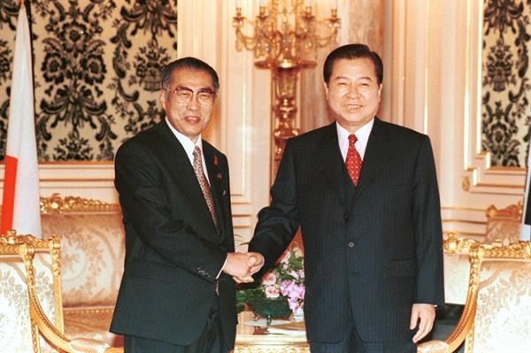 일본에 국빈으로 방문한 김대중 대통령이 1998년 10월 8일 도쿄 영빈관에서 오부치 게이조 일본 총리와 정상회담을 갖기에 앞서 악수하고 있다. 자료사진