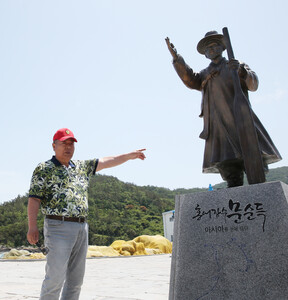 문종옥 진리 이장이 홍어 장수 문순득 동상 앞에서 그의 일생을 설명하고 있다.