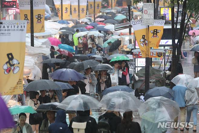 [서울=뉴시스] 권창회 기자 = 전국에 비가 내리고 있는 5일 오후 서울 중구 명동거리에서 관광객들이 우산을 쓰고 이동하고 있다. 2023.05.05. kch0523@newsis.com