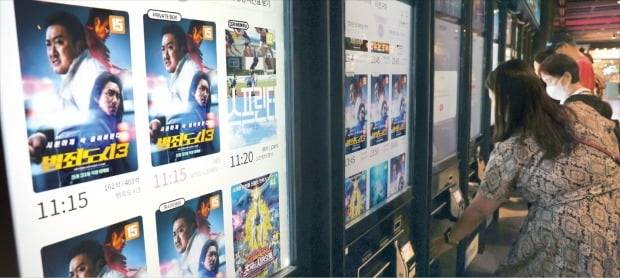 국내 4대 투자·영화배급사가 개봉한 영화가 올 들어 코로나19 이전의 3분의 1 수준으로 쪼그라들었다. 인건비 상승 등으로 제작비가 급증한 여파다. 서울의 한 영화관에서 관람객이 티켓을 사고 있다. /강은구 기자