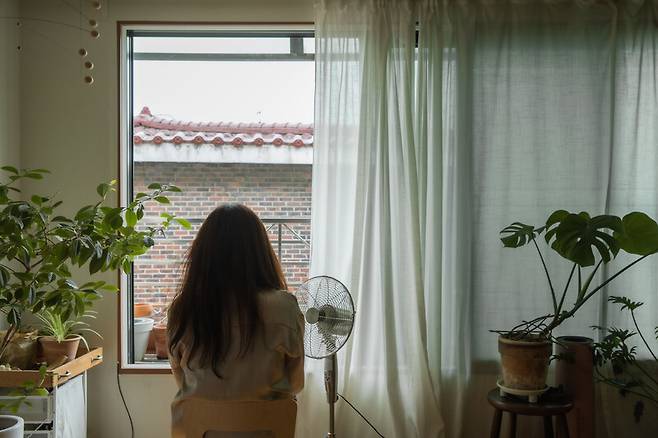 지난 2일 이현진씨가 서울시 성동구 집에서 선풍기 바람을 쐬며 더위를 식히고 있다. 스튜디오 어댑터 염서정