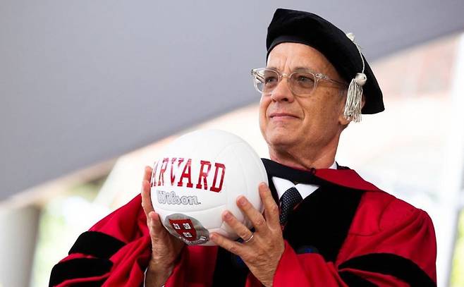 배우 톰 행크스가 하버드대 졸업식 연설에서 영화 ‘캐스트 어웨이’에 나왔던 윌슨 배구공을 선물 받은 모습. 하버드대 홈페이지