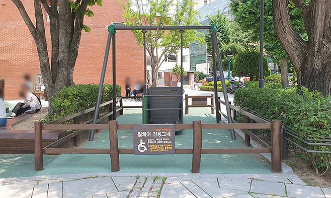 서울 종로구 마로니에 공원 어린이 놀이터에 설치된 휠체어 그네. 다가서니 ‘안전사고 예방을 위해 휠체어 사용자 외 이용을 금한다’면서 아울러 그네 탑승 시 동행인을 당부한 종로구 명의 안내문이 보였다.