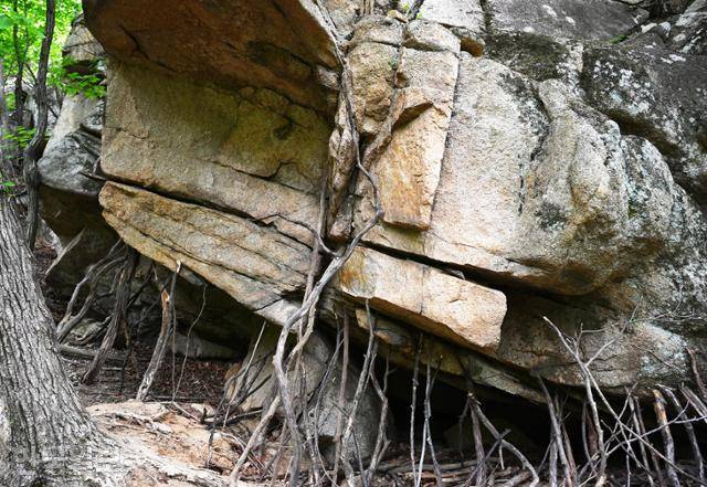 아슬아슬 기울어진 바위 아래에 등산객이 나무지팡이를 받쳐 놓았다.