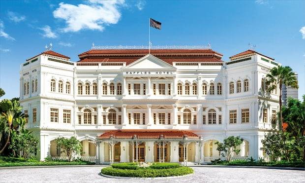 영국 콜로니얼 양식으로 지어진 래플스 싱가포르. 지금과 같은 모습으로 1915년 증축됐다. 로비 앞 여행객들을 태운 마차가 지나던 길은 100여 년 전과 마찬가지로 자갈로 이뤄져 있다. 래플스호텔 제공
