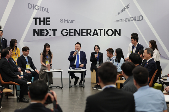 President Yoon Suk Yeol, center, speaks with youths at the Korea-Vietnam Digital Future Generation Dialogue at the Samsung Electronics R&D Center Vietnam in Hanoi on Saturday. [JOINT PRESS CORPS]