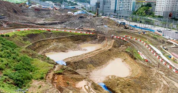 17일 부산 남구 대연3구역주택재개발 공사장 일원에 조성된 토사유출 방지용 구덩이 ‘침사지’에 물이 고여 있다. 이곳은 최근 집중호우에 토사가 휩쓸려 일대 하수관로가 막히는 피해가 발생해, 침사지 추가 확대 공사를 진행하고 있다. 이원준 기자 windstorm@kookje.co.kr