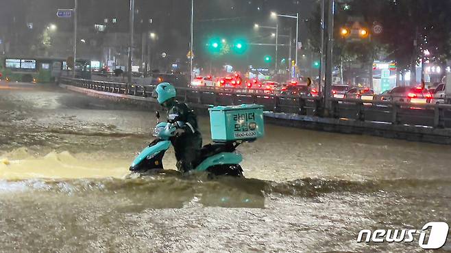 지난해 8월 서울 관악구 범람한 도림천 주변을 지나는 배달 라이더. /사진=뉴스1
