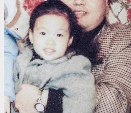 어린 시절 아버지 품에 안겨 환히 웃고 있는 황웃는돌 작가. 황 작가가 가져온 사진을 촬영했다. 김경록 기자