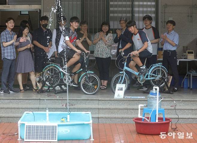 14일 서울 동작구 국사봉중학교에서 열린 생태축제에서 최두환 군(왼쪽)이 전기를 만드는 모터가 부착된 자전거로 분수를 올리고
있다. 김시우 군은 물통에 물을 채우고 있다. 기후 위기를 교육으로 극복하자는 생태전환교육은 학생들이 쉽게 접근할 수 있는 생태
스포츠를 통해 교육 현장에 스며들고 있다. 송은석 기자 silverstone@donga.com