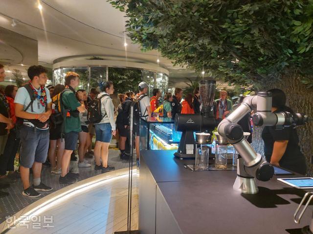 10일 오후 서울 중구 동대문디자인플라자에서 스위스에서 온 잼버리 대원들이 전시장을 둘러보고 있다. 전시장 안 카페에서 로봇이 커피를 제조하고 있다. 서현정 기자