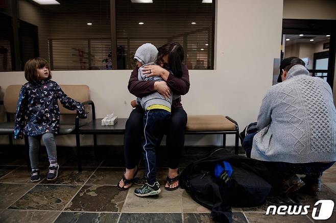 18일(현지시간) 산불로 대피령이 내려진 캐나다 옐로나이프에서 항공기를 타고 앨버타주에 도착한 한 이재민 가족이 서로를 껴안고 울고 있다. 2023.08.18/ ⓒ AFP=뉴스1 ⓒ News1 권진영 기자
