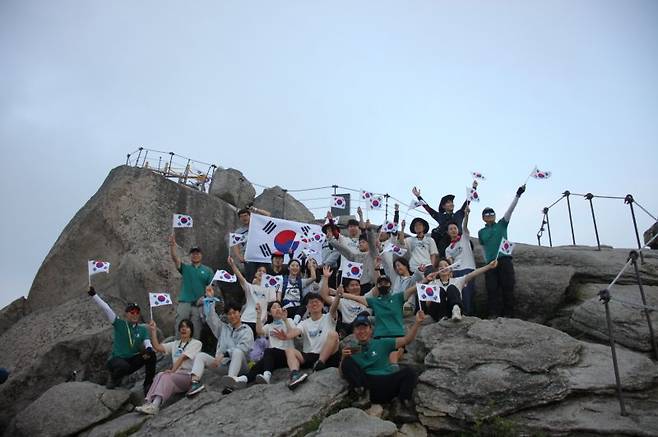 지난 18일 블랙야크강태선나눔재단 관계자와 블랙야크청년셰르파들이 북한산에서 산림 정화 캠페인 클린마운틴 활동 후 태극기 퍼포먼스를 진행하고 있다. 블랙야크 제공