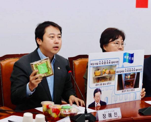 장예찬(왼쪽) 국민의힘 청년최고위원이 28일 오전 최고위원회에서 이재명 더불어민주당 대표가 경기지사 시절 매일 아침 공무원을 시켜 사 먹었다는 ‘조찬세트’를 공개하고 있다. 장예찬 페이스북 갈무리