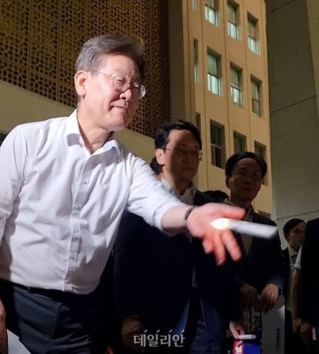 이재명 더불어민주당 대표가 1일 오후 국회본청 앞 계단에서 제1차 윤석열정권 폭정 저지 민주주의 회복 촛불문화제를 마친 뒤 여성 지지자들에게 자신이 사용하던 모형 LED 촛불을 던져주며 미소를 짓고 있다. 여성은 촛불을 받아든 뒤 이를 꼬옥 끌어안았다. ⓒ데일리안 김찬주 기자