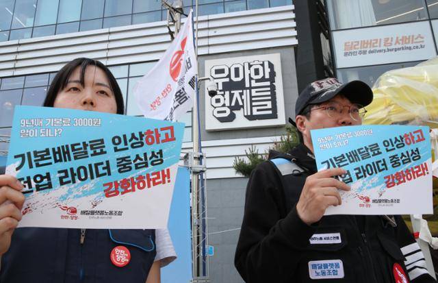 민주노총 배달플랫폼노동조합 회원들이 올해 5월 서울 송파구 배달의민족 본사 앞에서 '배달의민족 라이더 2차 파업' 기자회견을 하고 있다. 이들은 "배달의민족은 소비자와 자영업자로부터 꾸준히 배달비를 올려 왔지만 배달노동자에게 지급하는 '기본 배달료'는 9년째 3,000원으로 동결 중"이라며 "지난해 기록한 영업이익 4,200억 원은 모두 노동자를 지나치게 착취해서 얻은 이윤"이라고 비판했다. 뉴시스