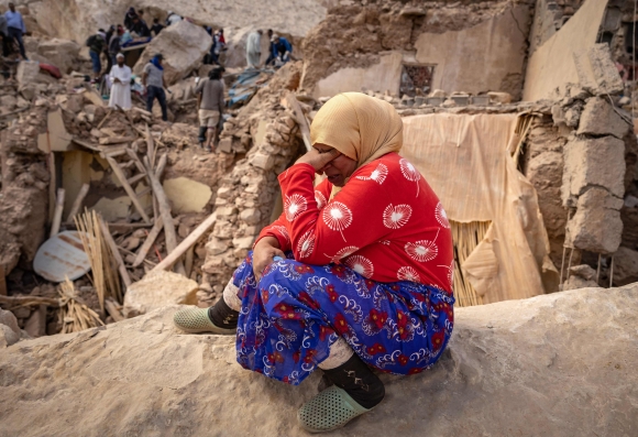10일(현지시간) 모로코 중부 아미즈미즈 인근에서 한 여성이 지진으로 무너진 건물 잔해에 걸터앉아 얼굴을 감싸쥐고 있다. 2023.9.10 AFP 연합뉴스