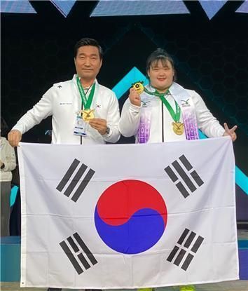 박혜정(오른쪽)이 자신을 고양시청으로 영입한 최종근 감독과 금메달을 나눠 걸고 함박웃음을 짓고 있다. ⓒ 대한역도연맹