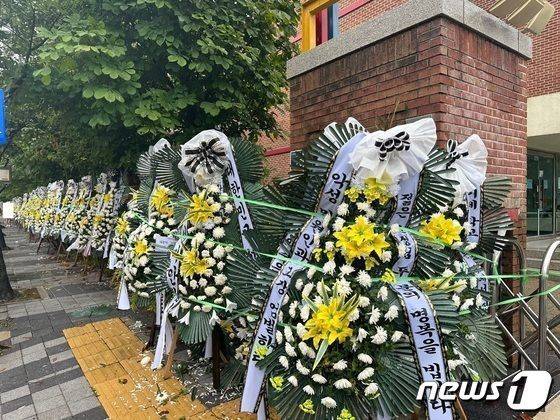 지난달 10일 오후 경기 의정부시 호원초등학교 일대에 조화가 줄지어 늘어선 모습. 전국 각지에서 젊은 두 교사의 죽음에 대한 진상규명을 촉구하는 문구를 써서 보냈다. /사진=뉴스1
