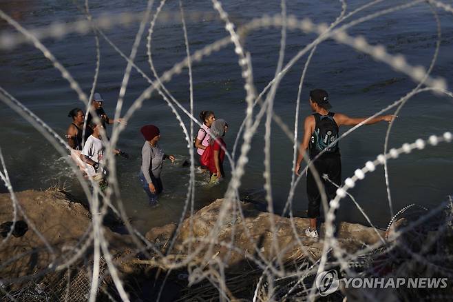 강 넘어 미국 향하는 중남미 이민자 (이글패스 AP=연합뉴스) 22일(현지시간) 멕시코 접경인 미국 텍사스 이글패스 인근 리오브라보(미국명 리오그란데강)에서 중남미 이민자들이 강둑을 따라 걷고 있다. 2023.9.23