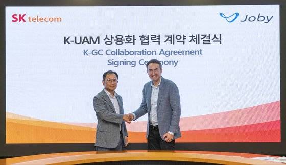 지난 20일 서울 중구 SK T타워에서 열린 '한국형 도심항공교통 실증사업(K-UAM 그랜드챌린지) 및 상용화를 위한 협력 계약식'에서 하민용 SKT CDO(왼쪽)와 에릭 앨리슨 조비 부사장이 기념 촬영하고 있다. 사진 SK텔레콤