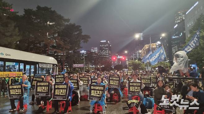 금속노조 조합원들이 20일 오후 8시쯤 '윤석열 퇴진'이 적힌 손팻말을 흔들고 있다. 양형욱 기자