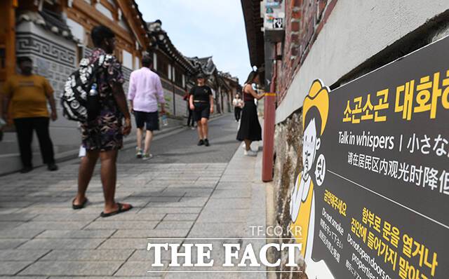 북촌한옥마을 담벼락에 '소곤소곤 대화해주세요'가 쓰인 안내판이 설치돼 있다.