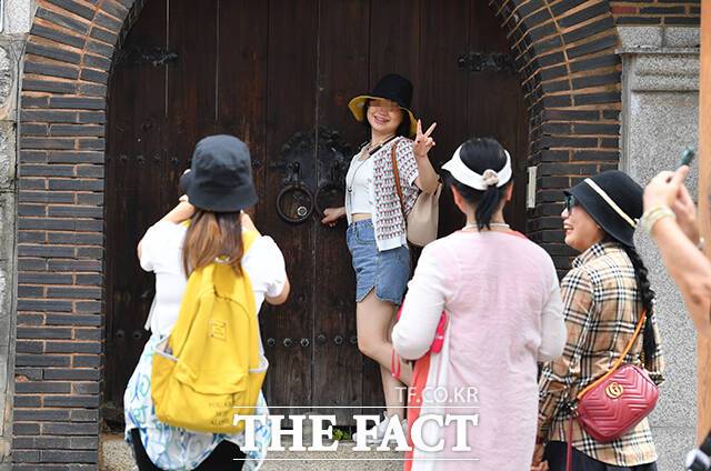 북촌한옥마을을 찾은 관광객들이 대문 앞에서 기념촬영을 하고 있다.
