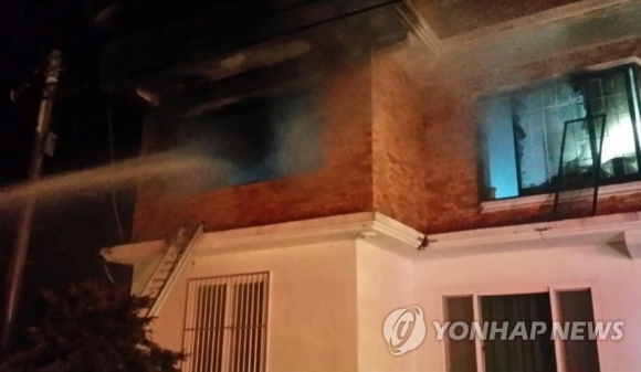 방화로 불 타고 있는 박씨 집에 소방대원들이 물을 뿌리고 있다. 집 안에 있던 일가족 4명이 모두 숨졌다. - 연합뉴스(속초소방서 제공)