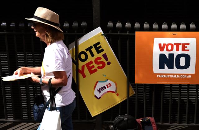3일 호주 시드니에서 한 여성이 호주민의 권리와 관련한 국민투표에 대한 찬반 포스터를 지나고 있다. 시드니=AFP 연합뉴스