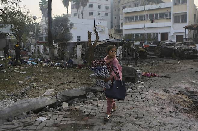 참사 다음날인 10월18일, 한 소녀가 담요를 들고 할아흘리 병원의 폭발 현장을 지나가고 있다. ⓒAP Photo