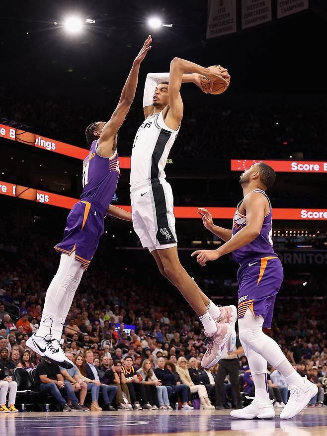11월 2일(현지 시각) 미국 애리조나주 피닉스 풋프린트 센터에서 열린 미국프로농구(NBA) 경기 전반 샌안토니오 스퍼스의 빅터 웬바냐마(가운데)가 피닉스 선즈의 케이타 베이츠-디오프(왼쪽)를 앞에두고 슬램 덩크를 시도하고 있다. /게티이미지/AFP 연합뉴스