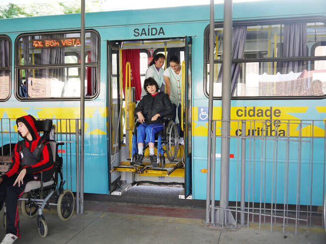브라질 쿠리치바시의 장애 학생들을 위한 안젤루 안토니우 달레그라비 터미널에서 2013년 4월22일 휠체어에 탄 장애 학생이 보조교사의 도움을 받아 전용 버스에서 내리고 있다. 한겨레 허호준 기자