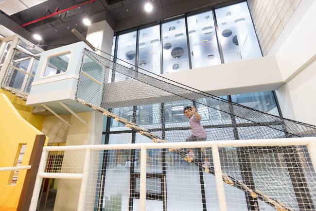 서울 동작구 제1호 시립 서울형 키즈카페에서 한 남자 어린이가 남산 케이블카를 형상화한 ‘빌딩미로숲’에서 경사진 스카이워크를 오르고 있다. 서울시청 제공