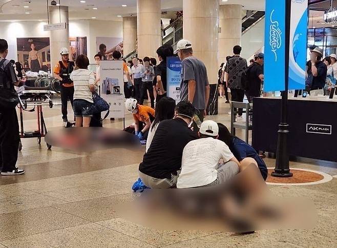 3일 오후 경기 성남시 분당구 서현역 한 백화점에서 흉기 난동 사건이 발생한 가운데 시민들이 피해자들에게 응급조치를 하고 있다./(독자 제공)뉴스1