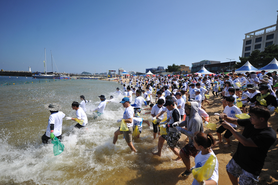 People jump into the water to catch squids at the squid-catching festival at Jangsa Port in Sokcho, Gangwon, in July 2018. [YONHAP]