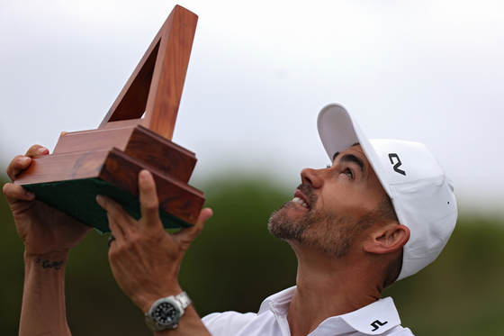 Camilo Villegas of Colombia celebrates looks skyward with the trophy after winning the Butterfield Bermuda Championship at Port Royal Golf Course in Southampton, Bermuda on Nov. 12. [GETTY IMAGES]
