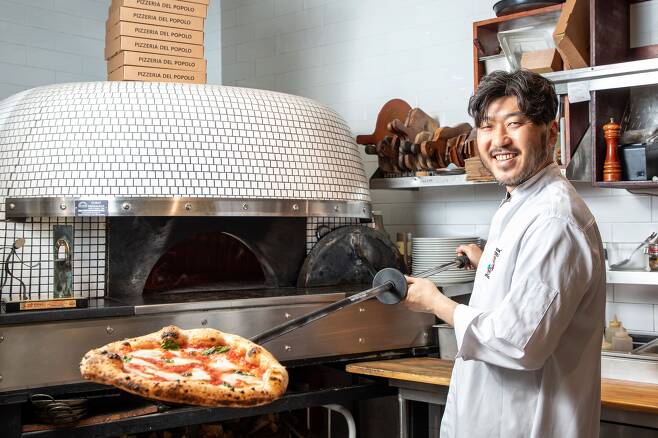 유준환 '포폴로피자' 대표가 장작 화덕에서 갓 구운 마르게리타 피자를 꺼냈다. 그는 "맛있으면서 소화 잘 되는 건강한 피자가 좋은 피자라고 생각한다"고 했다./장은주 영상미디어 객원기자