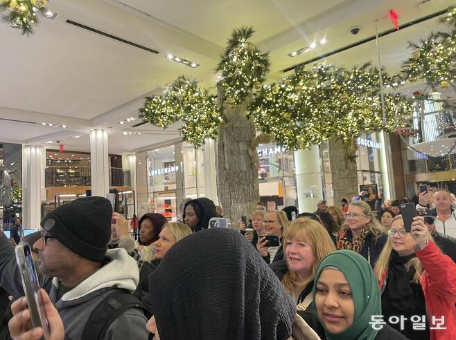 24일(현지 시간) 오전 6시경 미국 뉴욕 맨해튼 메이시스 백화점 문이 열리자 새벽부터 대기하던 소비자들이 사진을 찍으며 입장하고 있다. 뉴욕=김현수 특파원 kimhs@donga.com