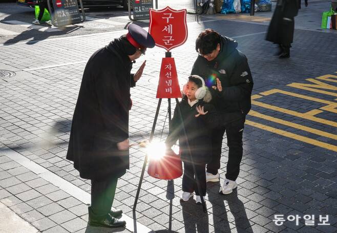 1일 오후 서울 중구 명동거리에서 한 가족이 구세군 자선냄비에 성금을 넣고 있다. 이한결 기자 always@donga.com