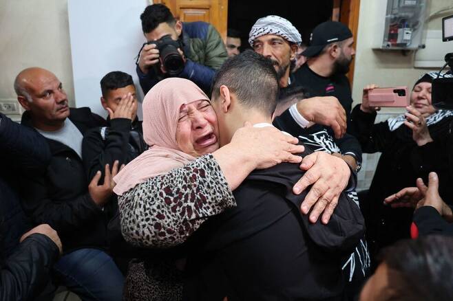 2) ‘일시적 교전 중단’ 합의에 따라 풀려난 아마드 살라미마가 11월28일 팔레스타인 땅 동예루살렘의 집에 도착하자, 가족들이 끌어안으며 눈물을 흘리고 있다. AFP 연합뉴스